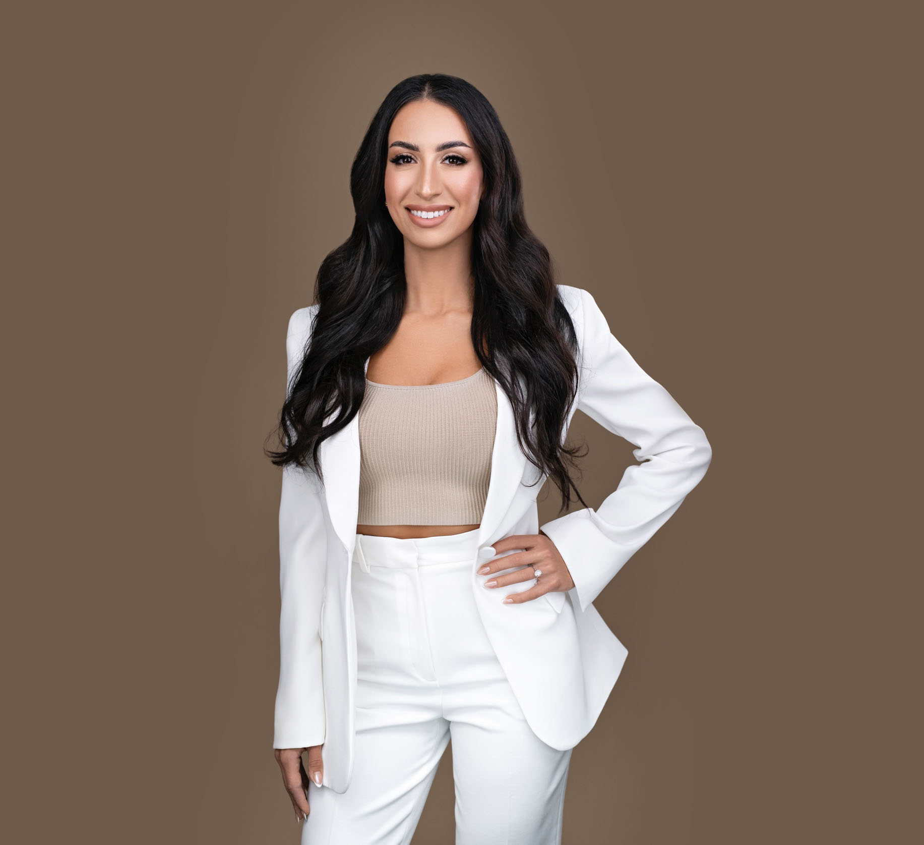 Beauty by Maria V - Maria Santurbano Headshot white suit on brown background